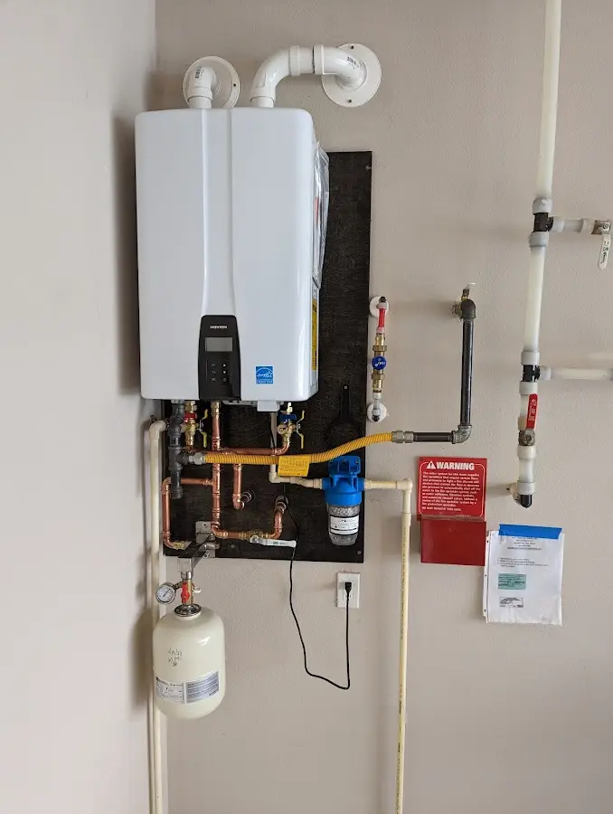 Professional plumber installing copper piping in a Hopkins home